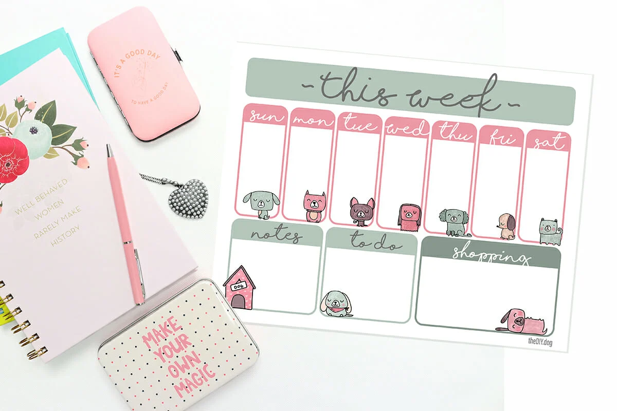 a day planner, a cell phone case and a tin that says "make your own magic lay on a white table with a free printable weekly planner page featuring dog art.