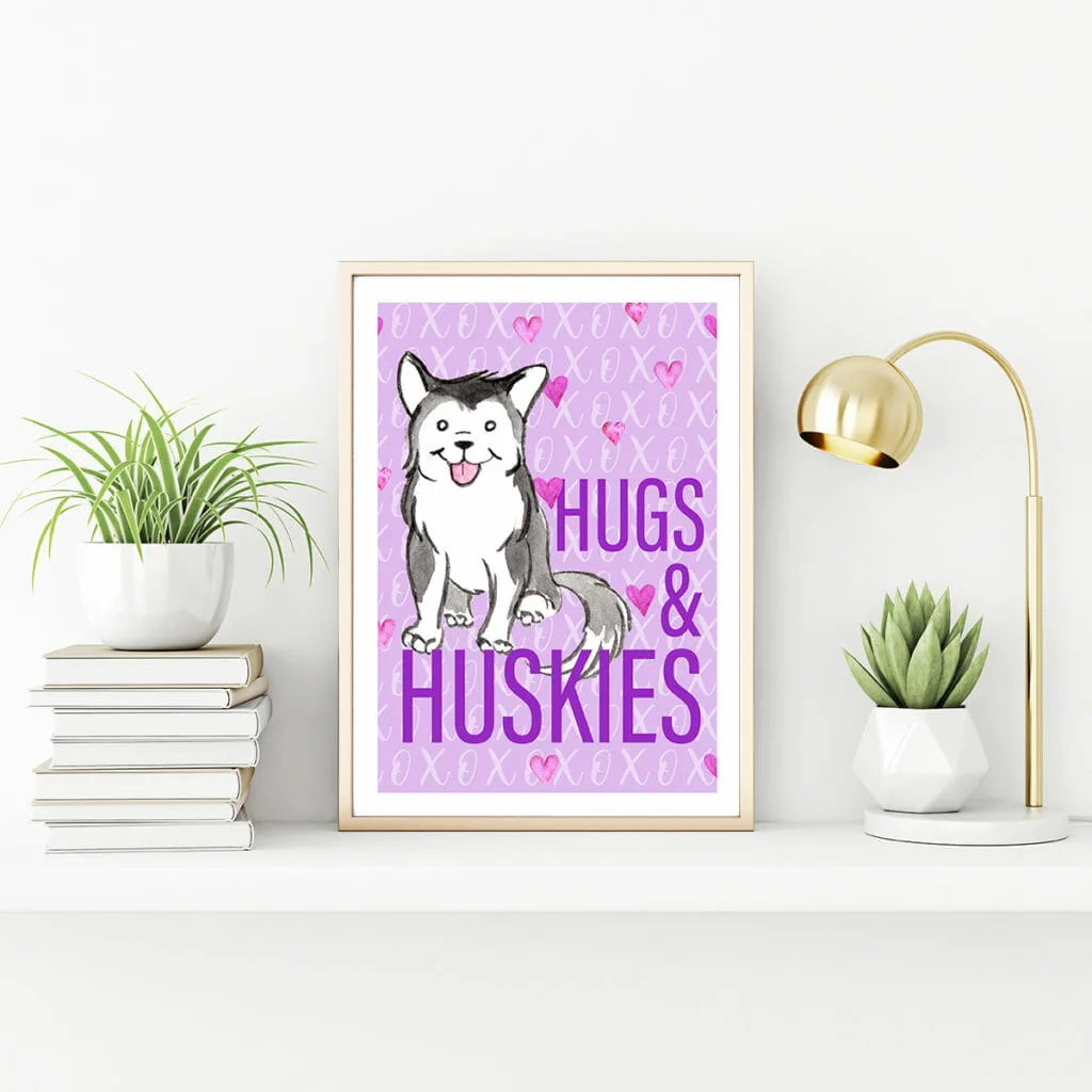 A vertical gold metal frame standing on the table with succulent plant, lamp and pile of books. In the frame a free printable art print with a purple background and a watercolour husky. Text reads: Hugs & Huskies.