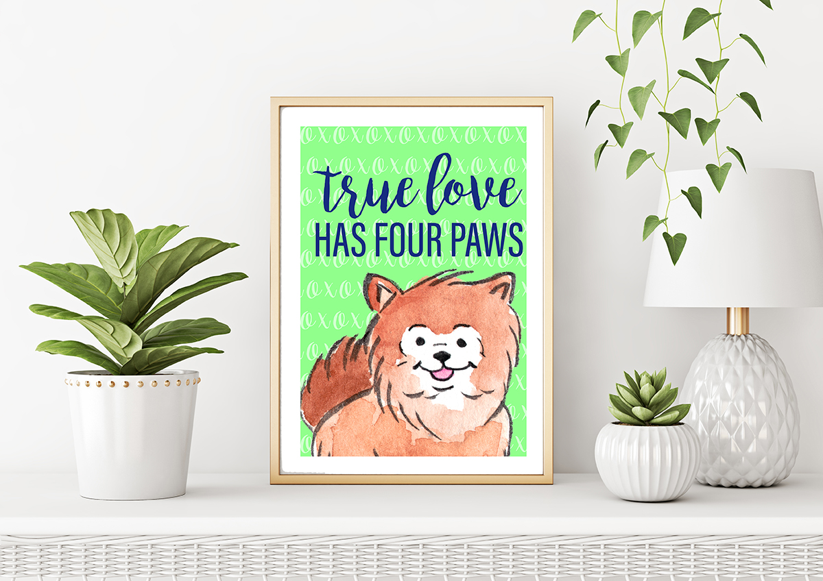 A vertical gold frame, plants in pots and lamp sit on a wicker table. In the frame a free printable art print with a green background and a watercolour pomeranian. Text reads: true love has four paws.