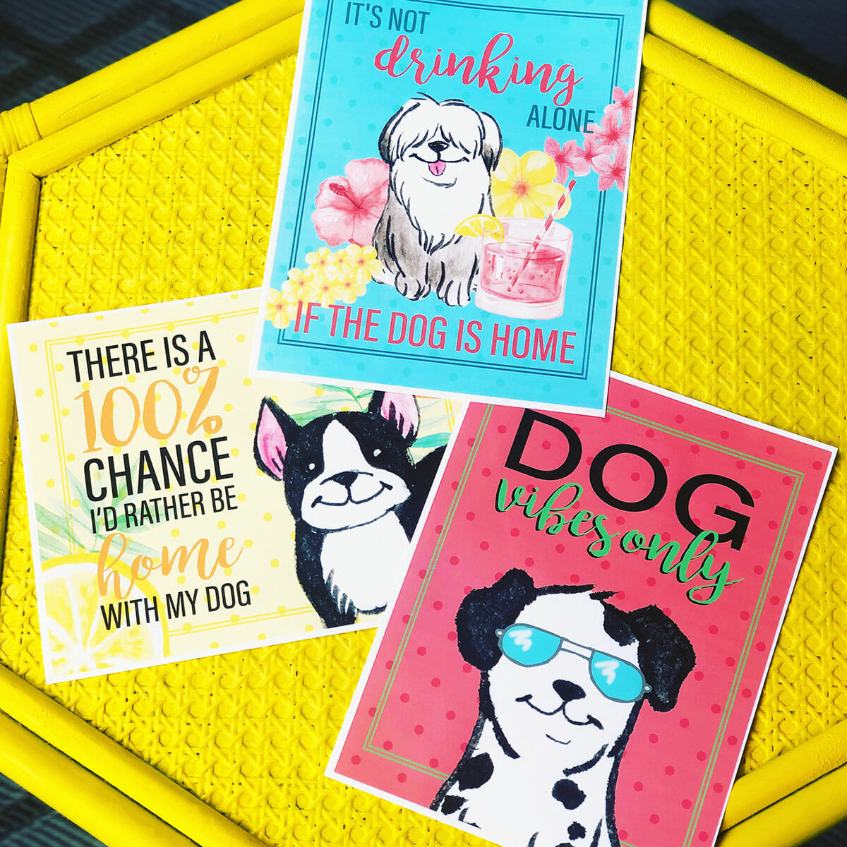 three printable summer dog art pieces sit on a bright yellow table