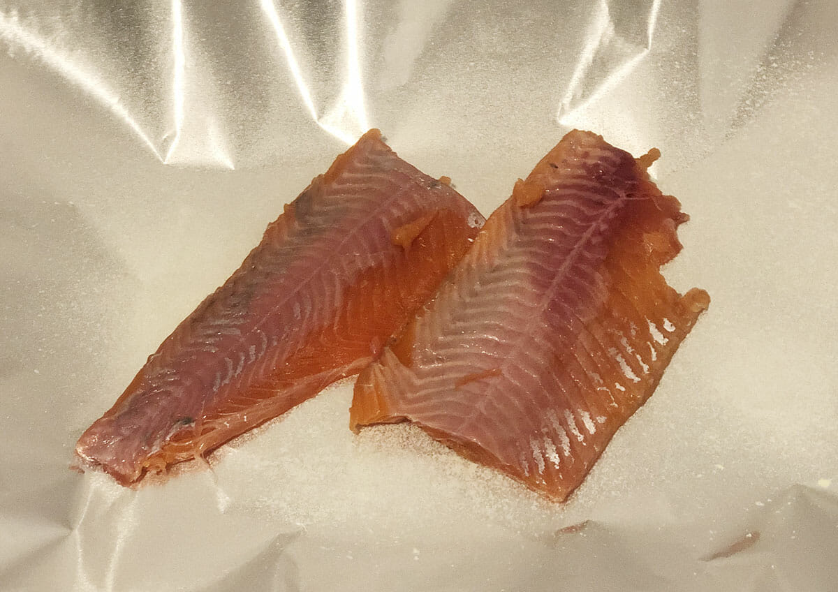 trout fillets sits in an oil-sprayed tin foil pouch