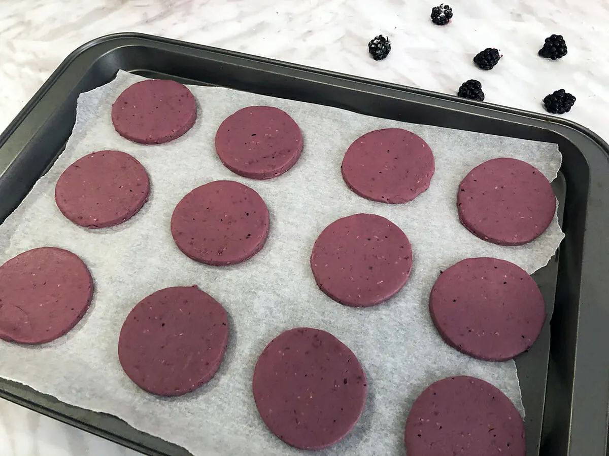 blackberry cheesecake dog biscuits cut out with a cookie butter and displayed on a baking sheet
