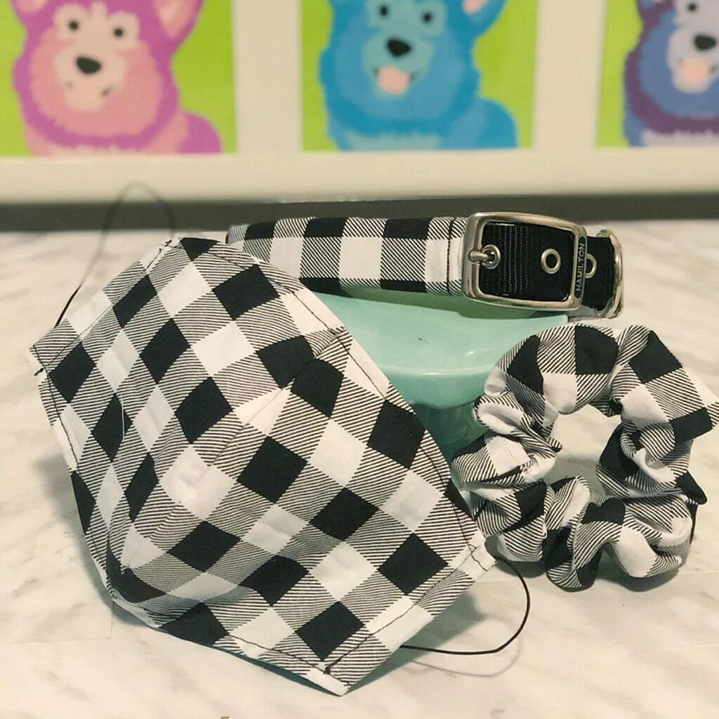 A matching black and white buffalo plaid DIY Dog Collar, Fabric Mask & Scrunchie on a white table